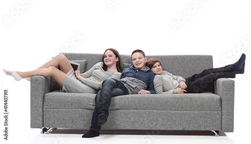 mom and her two sons relax sitting on the couch. © ASDF