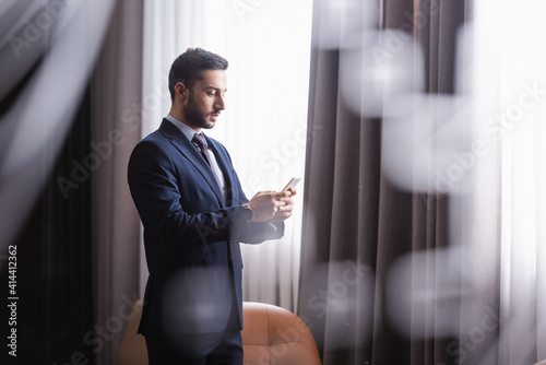 Arabian businessman using smartphone in modern restaurant