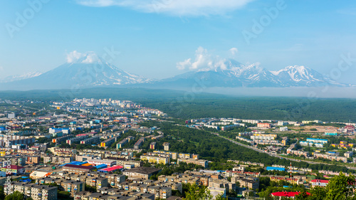 View of the city Petropavlovsk-Kamchatsky on background of Avachinsky, Koryaksky and Kozelsky Volcanoes. Russian Far East, Kamchatka Peninsula.