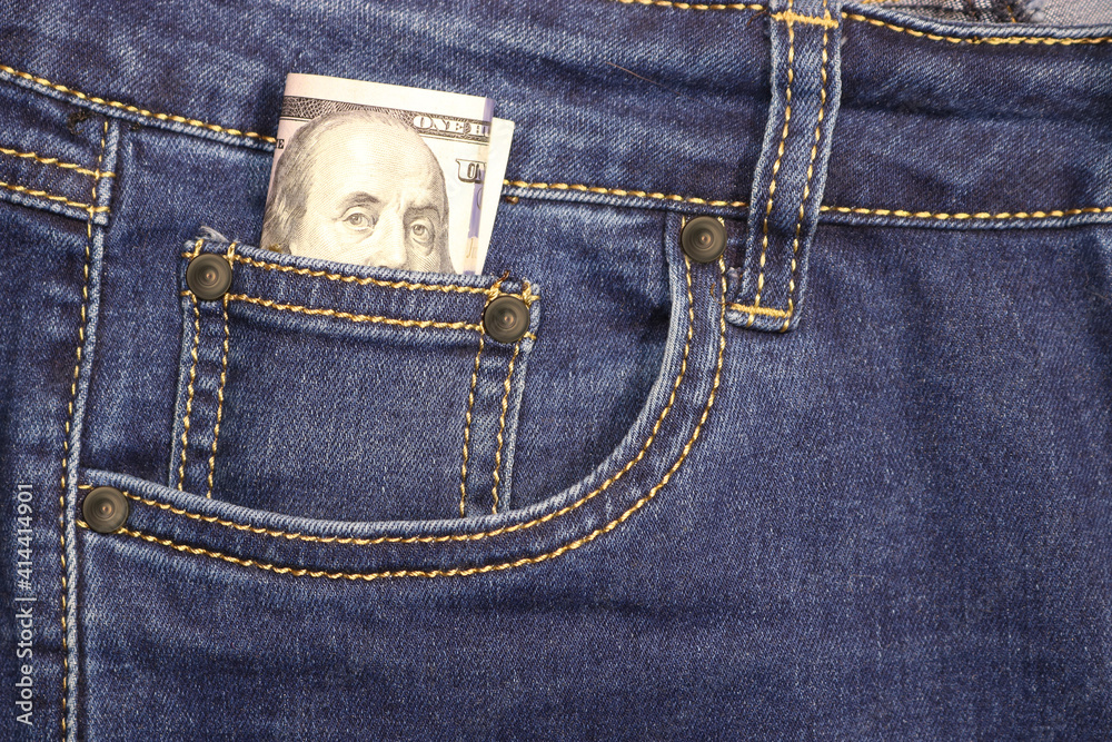 Stack of American hundred dollar bills in a pocket of blue jeans. Money in your pocket, cash. Stack of American hundred dollar bills in a pocket of blue jeans. Money in your pocket, cash.