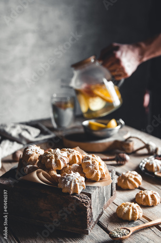 Man pours Hot tea with slices of fresh grapefruit on wooden tablet. Healthy drink, Eco, vegan.