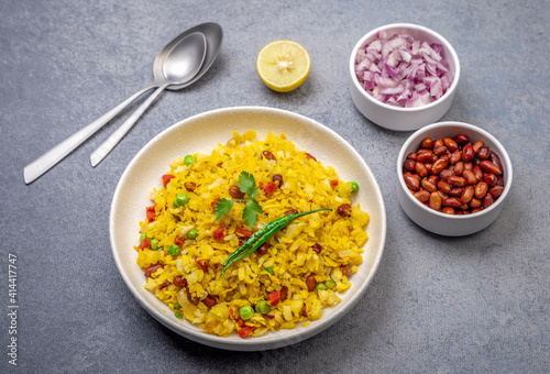 spicy Indian snack or breakfast  poha with onion and peanuts photo