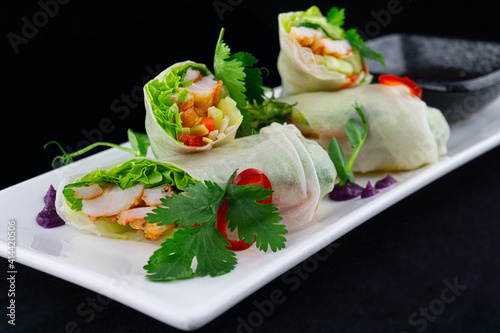 Vegetable rolls of pita. Bread rolls with vegetables inside. The pita bread wrapped cabbage, cucumber, feta cheese. The dish is decorated with lime and tomatoes.
