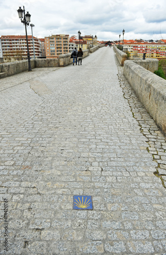 Pareja cruzando el puente medieval Puente romano Camino de Santiago camino sanabrés en Ourense Orense Galicia España photo