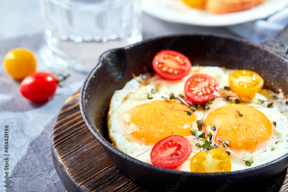 Fried eggs in cast-iron skillets. Sunny morning breakfast concept Fried eggs in cast-iron skillets. Sunny morning breakfast concept