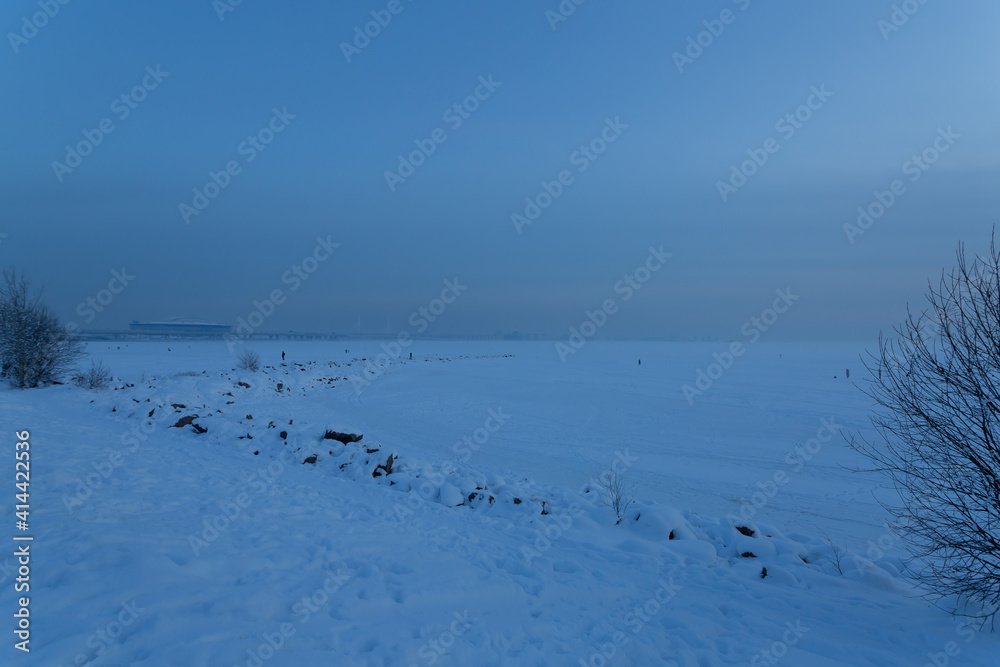 Frozen seashore of the Finnish Gulf at the 300 Years Park in the evening Saint Petersburg, Russia.