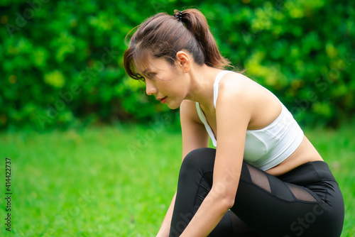 Young asian women warm up in a park before jogging.