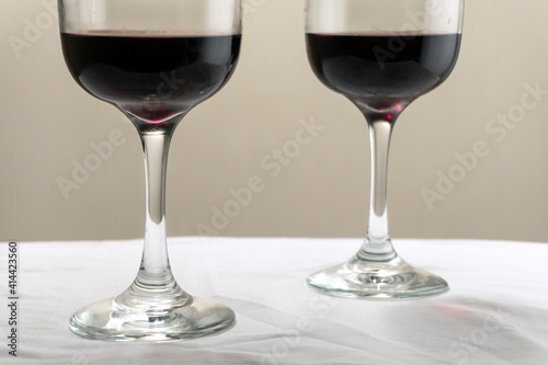 Two large glasses with red wine on a blurred background  close-up. Horizontal photo