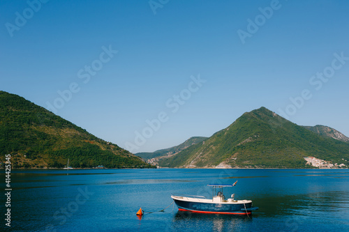 A blue fishing wooden boat moored in the Bay of Kotor near the town of Perast in Montenegro.
