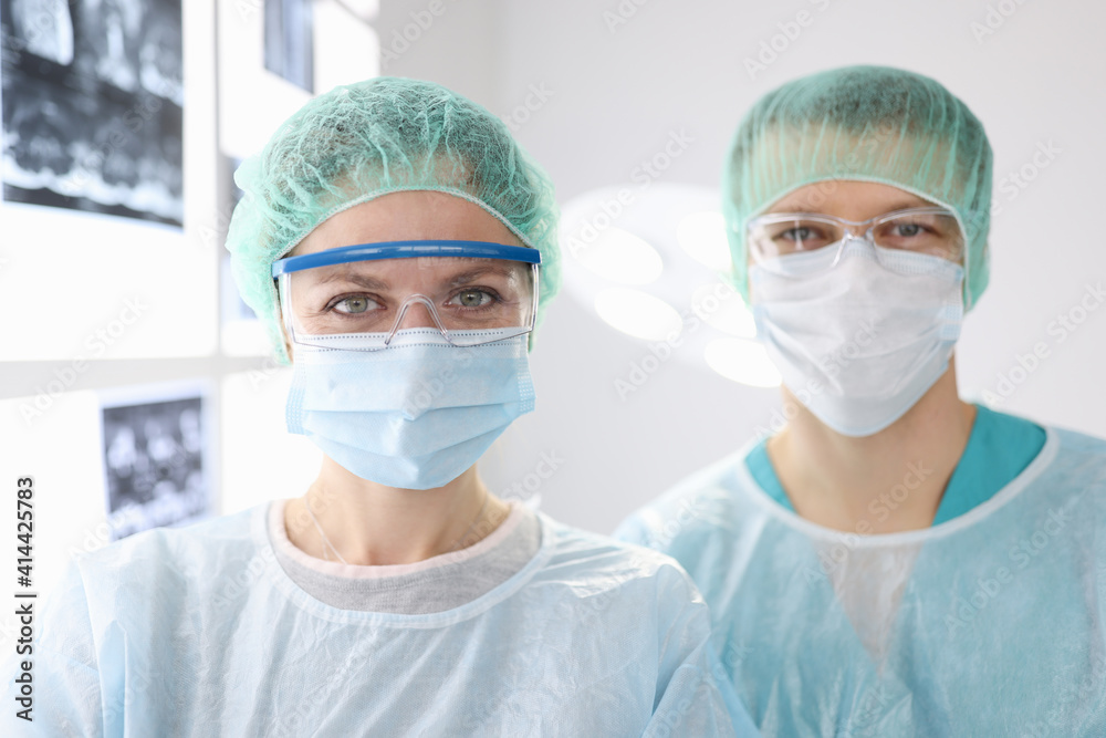 Portraits of doctors surgeons in protective clothing in clinic. Surgical care concept
