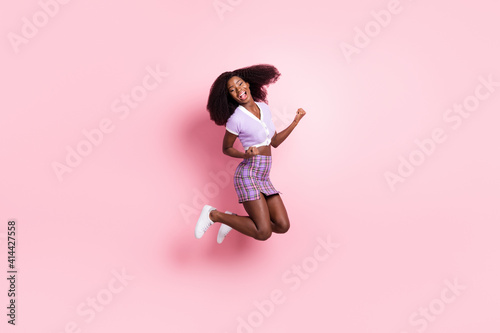 Full length body size view of pretty cool cheerful girl having fun jumping rejoicing isolated over pink pastel color background
