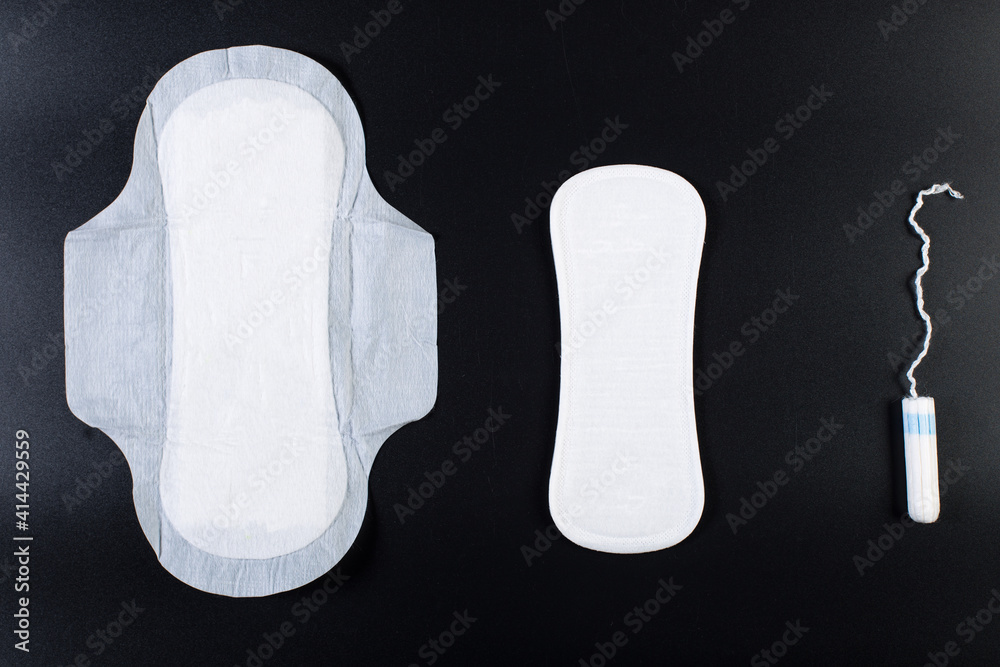 Foto de Pad, panty liner and tampon on black background. Feminine hygiene  products. do Stock