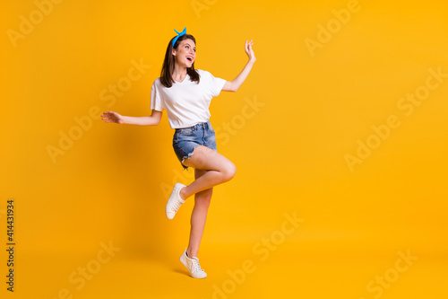 Fototapeta Naklejka Na Ścianę i Meble -  Full length body size view of skinny dreamy cheerful brown-haired girl jumping dancing isolated over bright yellow color background