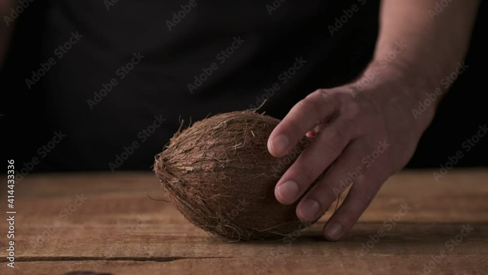 Man hands take coconut from the table, slow motion