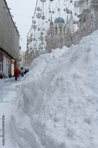 Large pile of snow on a pedestrian street in the city center.