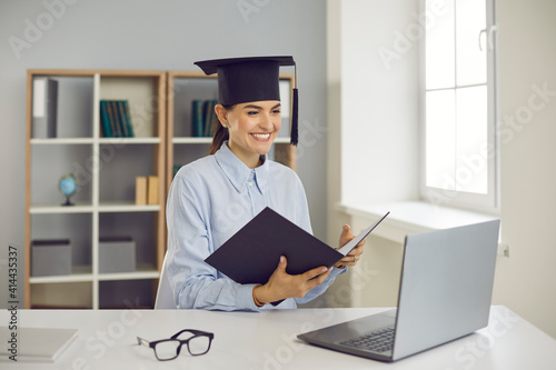 Getting degree online. Happy student graduating from business school, college or university. Smiling woman sitting at laptop computer and presenting course work, thesis or dissertation via video call photo