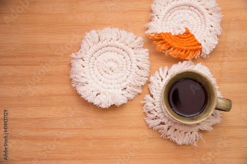 Macrame handmade Hobby.Top View black hot coffee in a cup on white macrame coasters with copy space