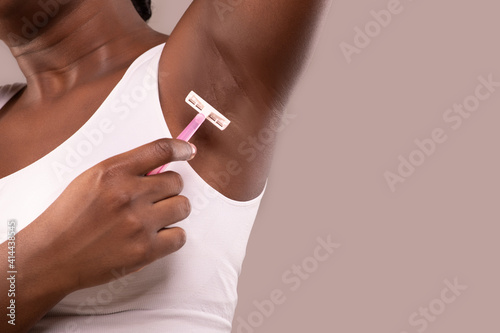 Hair Removal. Unrecognizable Black Woman Shaving Her Armpit With Pink Razor