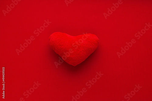 red soft heart on red background