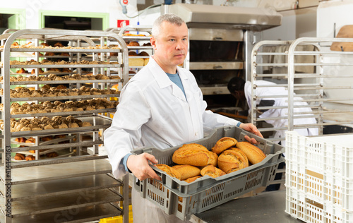 Baker sorts finished products at the bakery. High quality photo