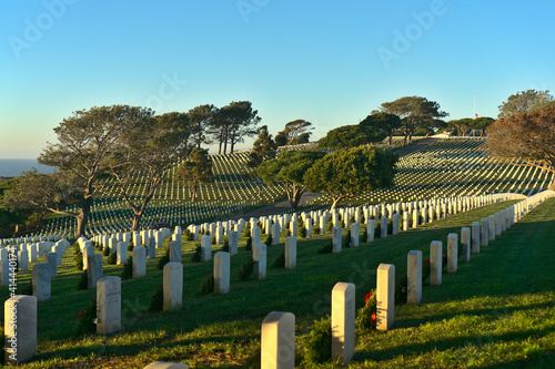 Sunset view of Fort Rosecrans National Cemetery overlooking the Pacific Ocean with American flag half mast in the background; Point Loma, San Diego, California
