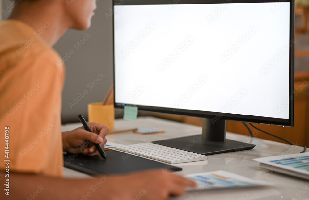Graphic designer working on digital board with mockup computer monitor blank screen. Graphic designer working on digital board with mockup computer monitor blank screen.
