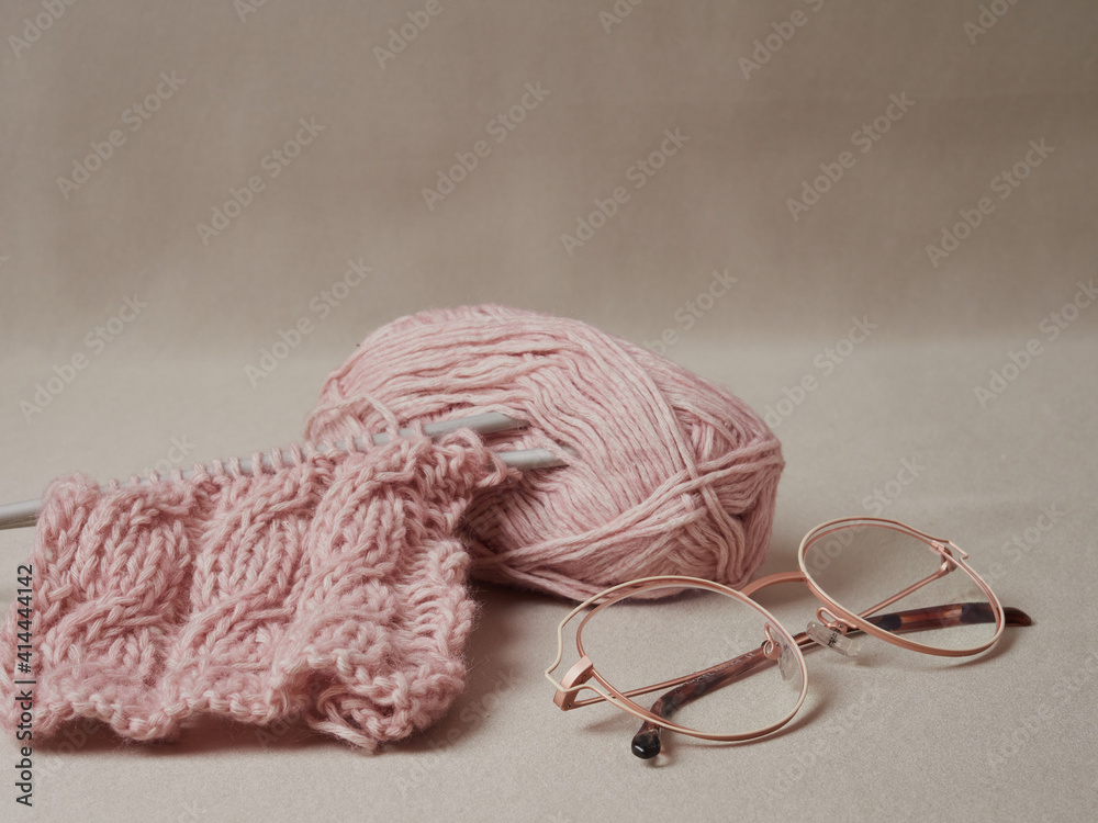 Fototapeta premium home hobbies, cozy knitted sweaters with a ball of yarn in the living room on a wooden background