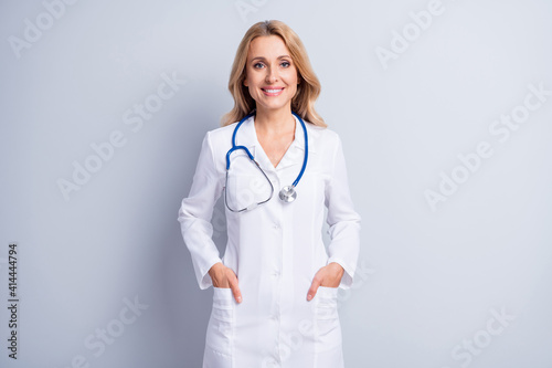 Photo of sweet confident age woman therapist dressed white coat arms pockets isolated grey color background