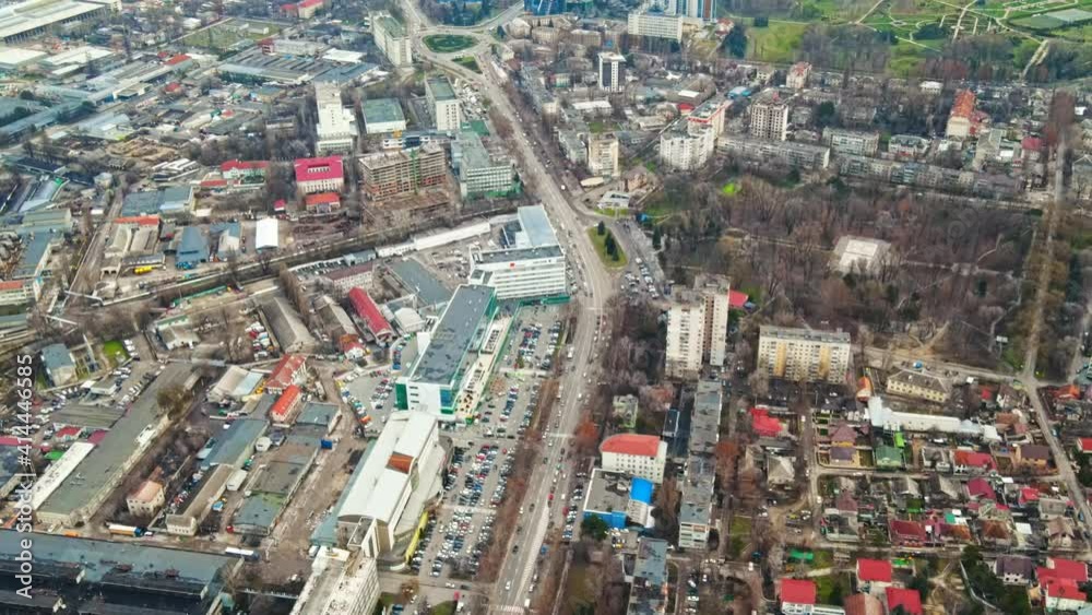 Aerial drone view of Chisinau. Panorama view of multiple buildings, roads with moving cars and bare trees. Moldova