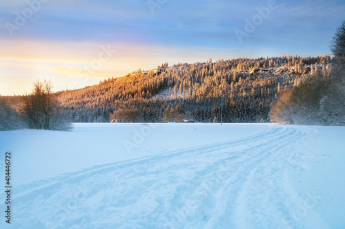 Cross country skiing. A magical start to a new day in the meadows of the Stolowe Mountains National Park in Poland. A wonderful sunrise in a wild land.