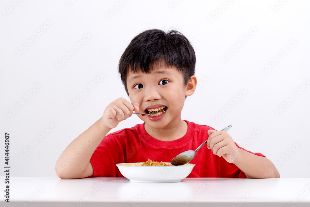 Portrait of cute little Asian boy enjoying eating noodles at home, isolated on white background Portrait of cute little Asian boy enjoying eating noodles at home, isolated on white background
