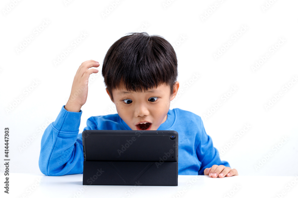 Shocked and surprised little Asian boy on the internet with tablet computer isolated on white background. Shocked and surprised little Asian boy on the internet with tablet computer isolated on white background.