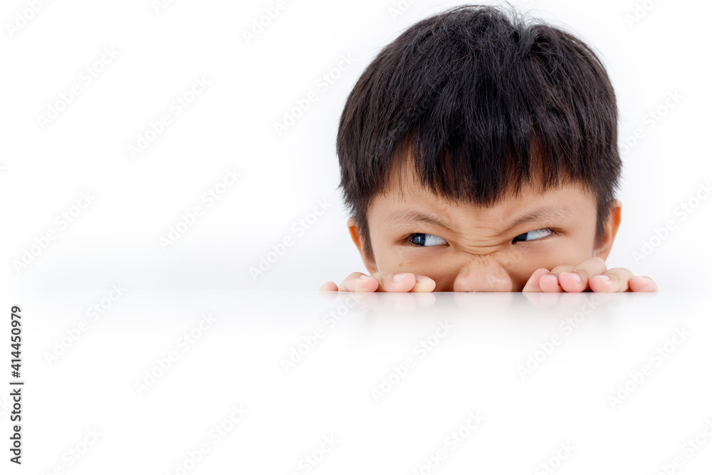 Portrait of an Asian boy peeking through the surface of table isolated on white background. Portrait of an Asian boy peeking through the surface of table isolated on white background.