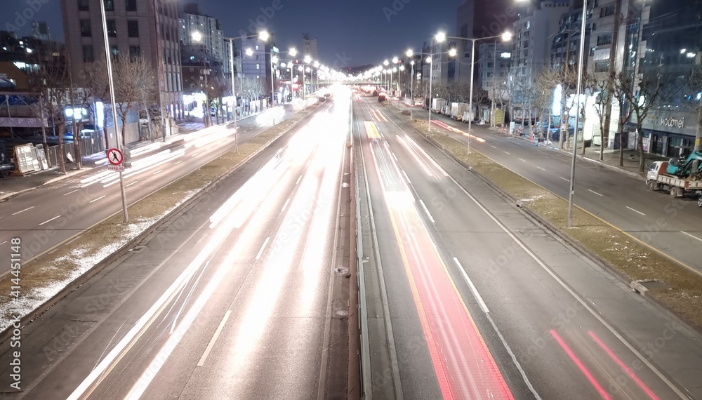 Cars moving fast on city roads at night
