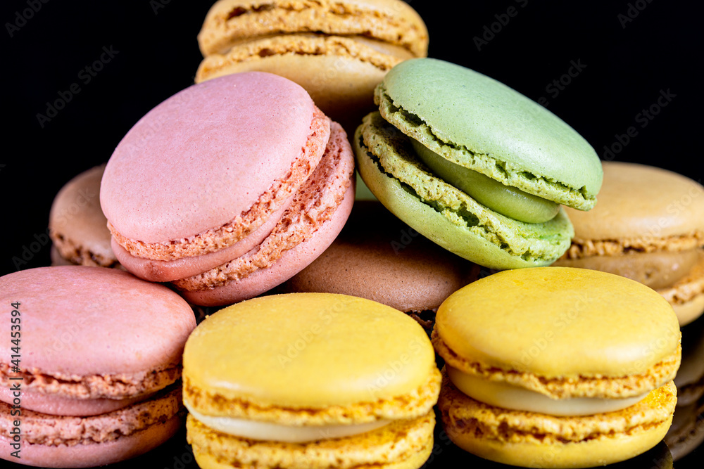 close up multicolored macarons on black background close up multicolored macarons on black background
