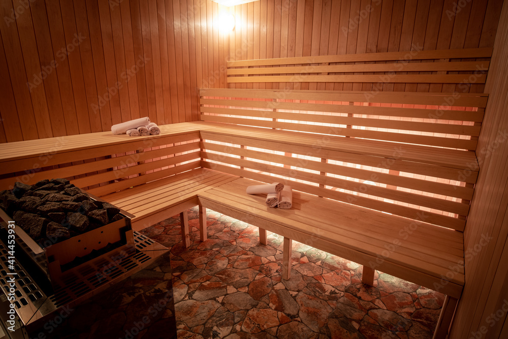 Empty wooden sauna with towels and a heater. Led panel under wooden  benches. Stock Photo | Adobe Stock
