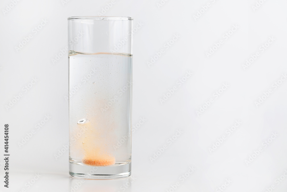 Orange effervescent tablet dissolving in water Orange effervescent tablet dissolving in water