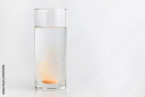 Obraz na plátne Orange effervescent tablet dissolving in water