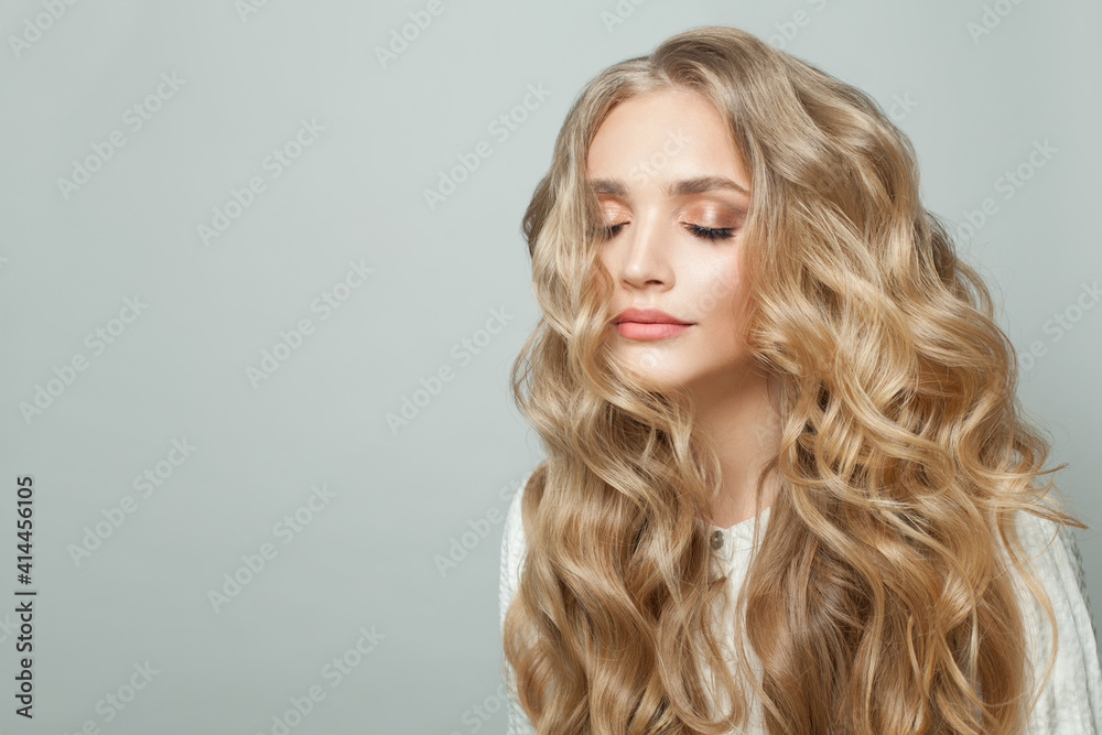 Attractive woman with long blonde healthy curly hair on white background - obrazy, fototapety, plakaty 
