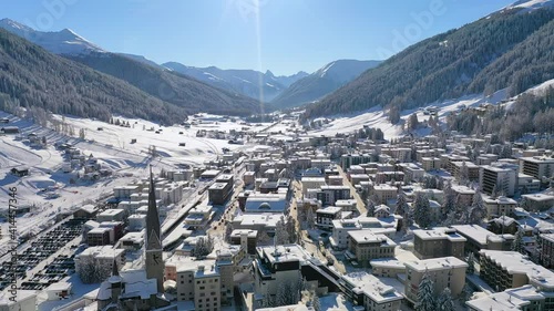 Davos, Switzerland: Aerial view of famous Swiss Alpine ski resort town in winter, buildings and slopes covered in snow - landscape panorama of Alps mountain range from above, Europe photo