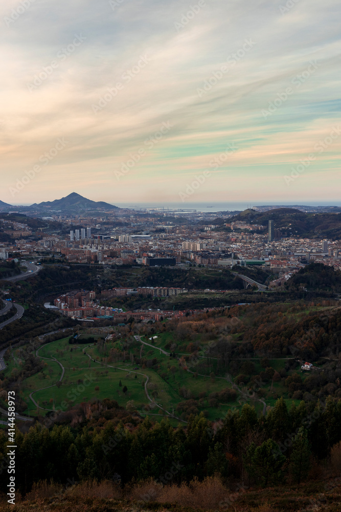 view of the city of bilbao from a mount at sunset