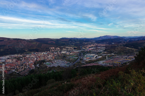 view of the city of bilbao from a mount at sunset