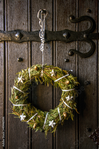 Vertical shot of aChristmas wreath on a door in Auvergne-Rhone-Alpes, France photo