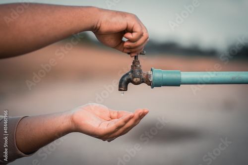 Open old faucet and grunge and drip water, water shortage idea.