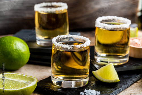 Mexican Gold Tequila with lime and salt on rustic wooden background. Alcoholic drink concept. Mexican national drink Close up