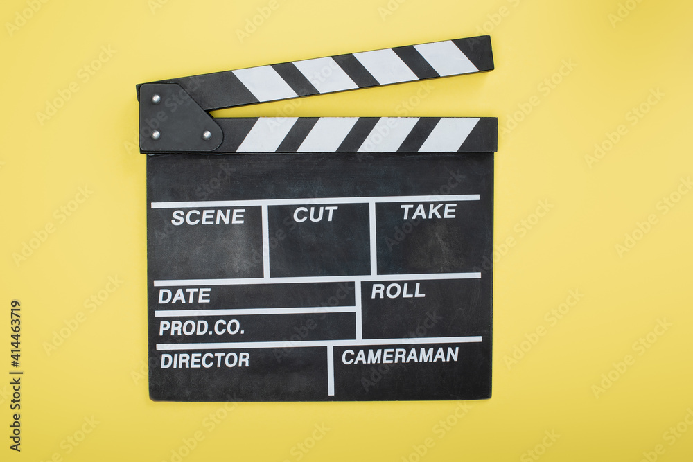 top view of clapperboard on yellow, cinema concept