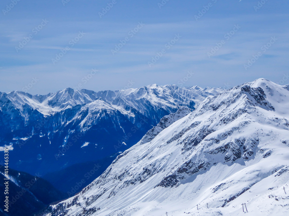 Fototapeta premium Beautiful and serene landscape of mountains covered with snow in Moelltaler Gletscher, Austria. Thick snow covers the slopes. Clear weather. Perfectly groomed slopes. Massive ski resort.