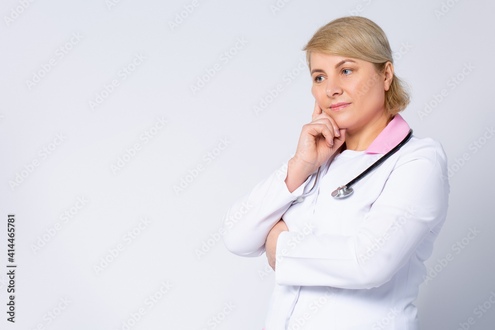 Thoughtful senior female doctor looking in distance lost in thoughts. Worried old physician thinking of healthcare question, concerned of challenge, feels anxious, difficult decision. Side gray space Thoughtful senior female doctor looking in distance lost in thoughts. Worried old physician thinking of healthcare question, concerned of challenge, feels anxious, difficult decision. Side gray space