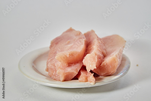 Pieces of Raw chicken meat on plate on white background