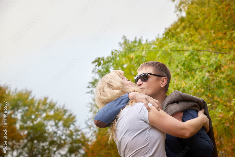 Middle-aged couple walking in the park on an autumn day. Middle-aged couple walking in the park on an autumn day.